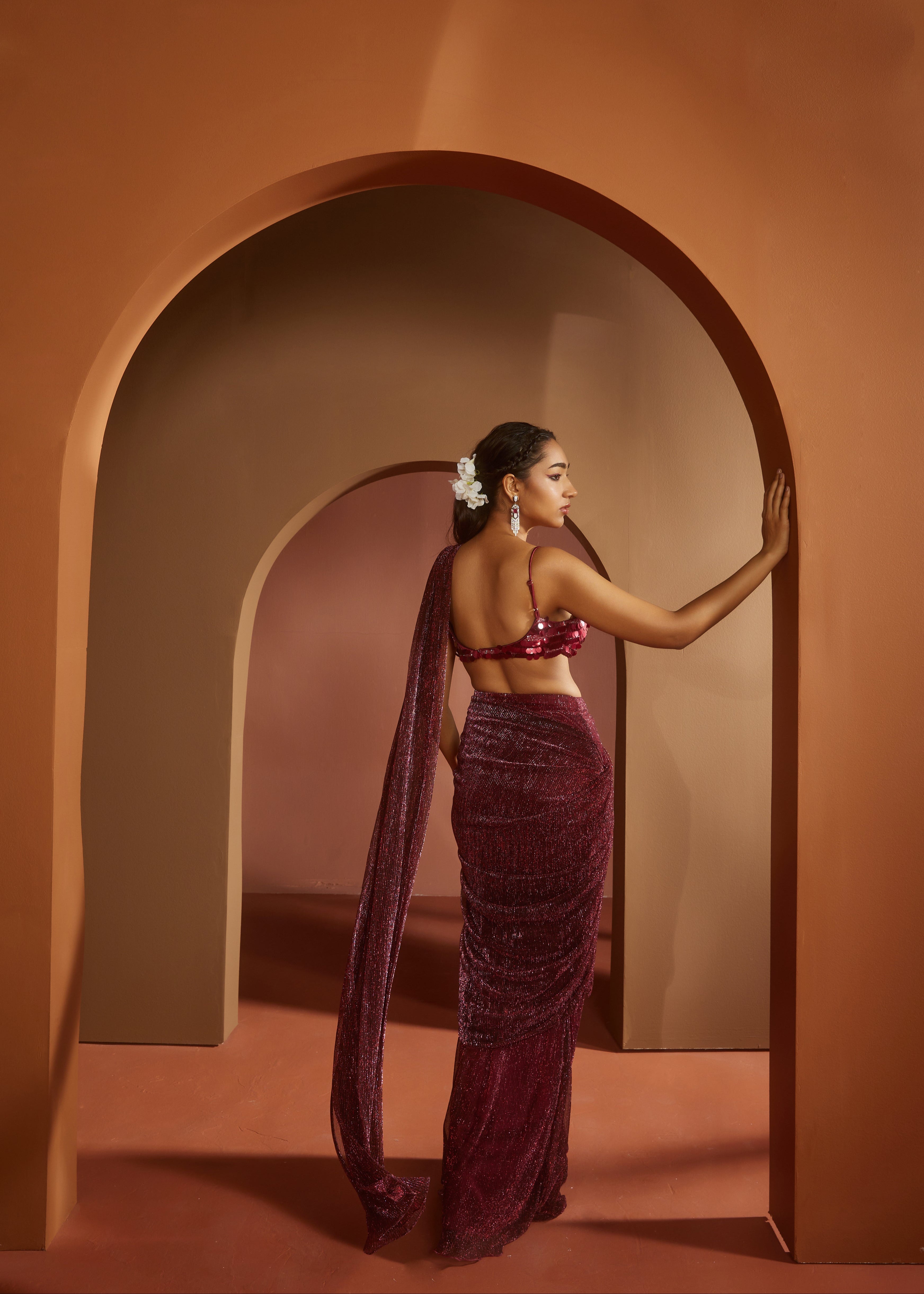 Chic woman in a Humaida Maroon Shimmer Pre-Draped Saree Set, exuding vibrant elegance