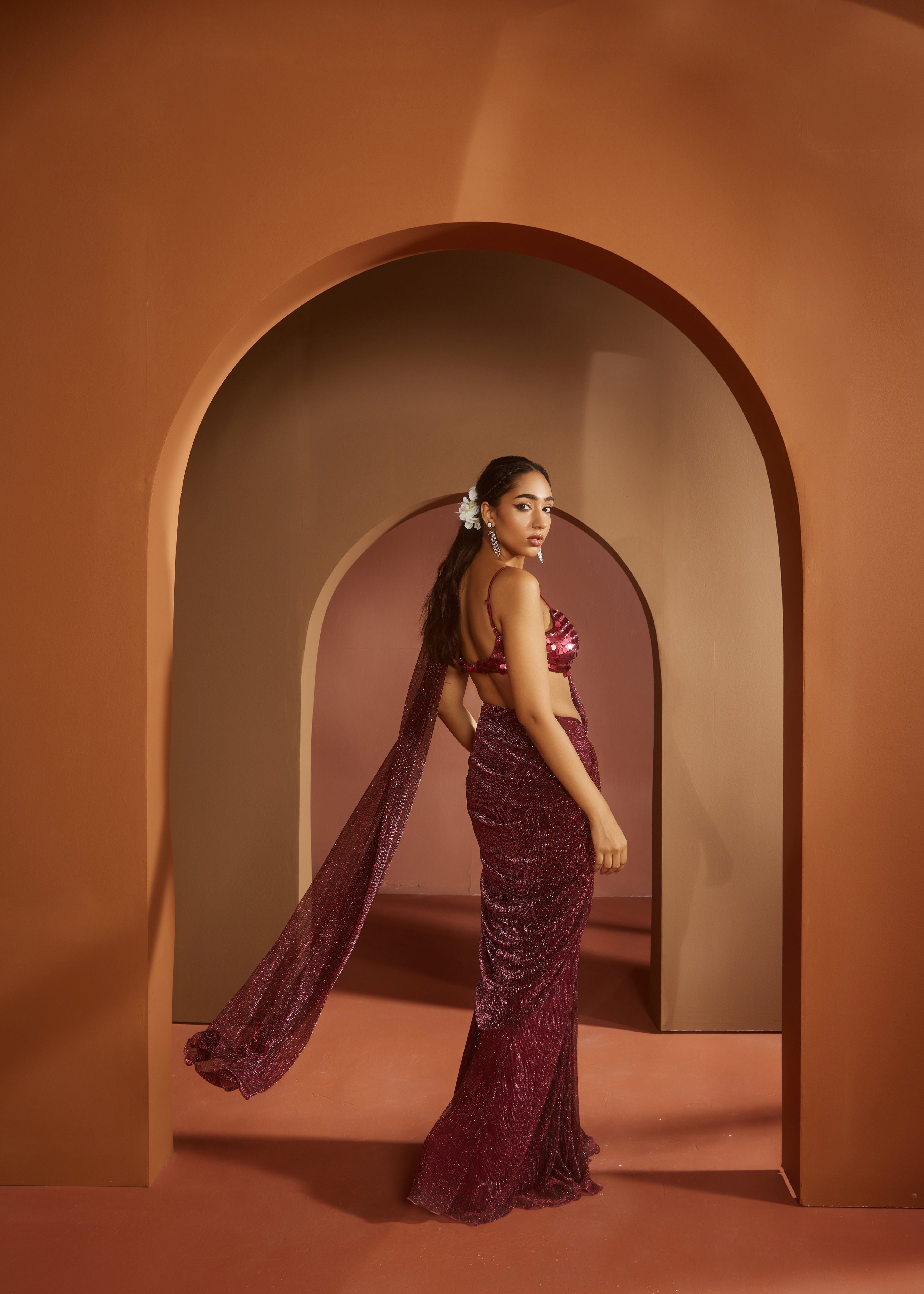 Chic woman in a Humaida Maroon Shimmer Pre-Draped Saree Set, exuding vibrant elegance