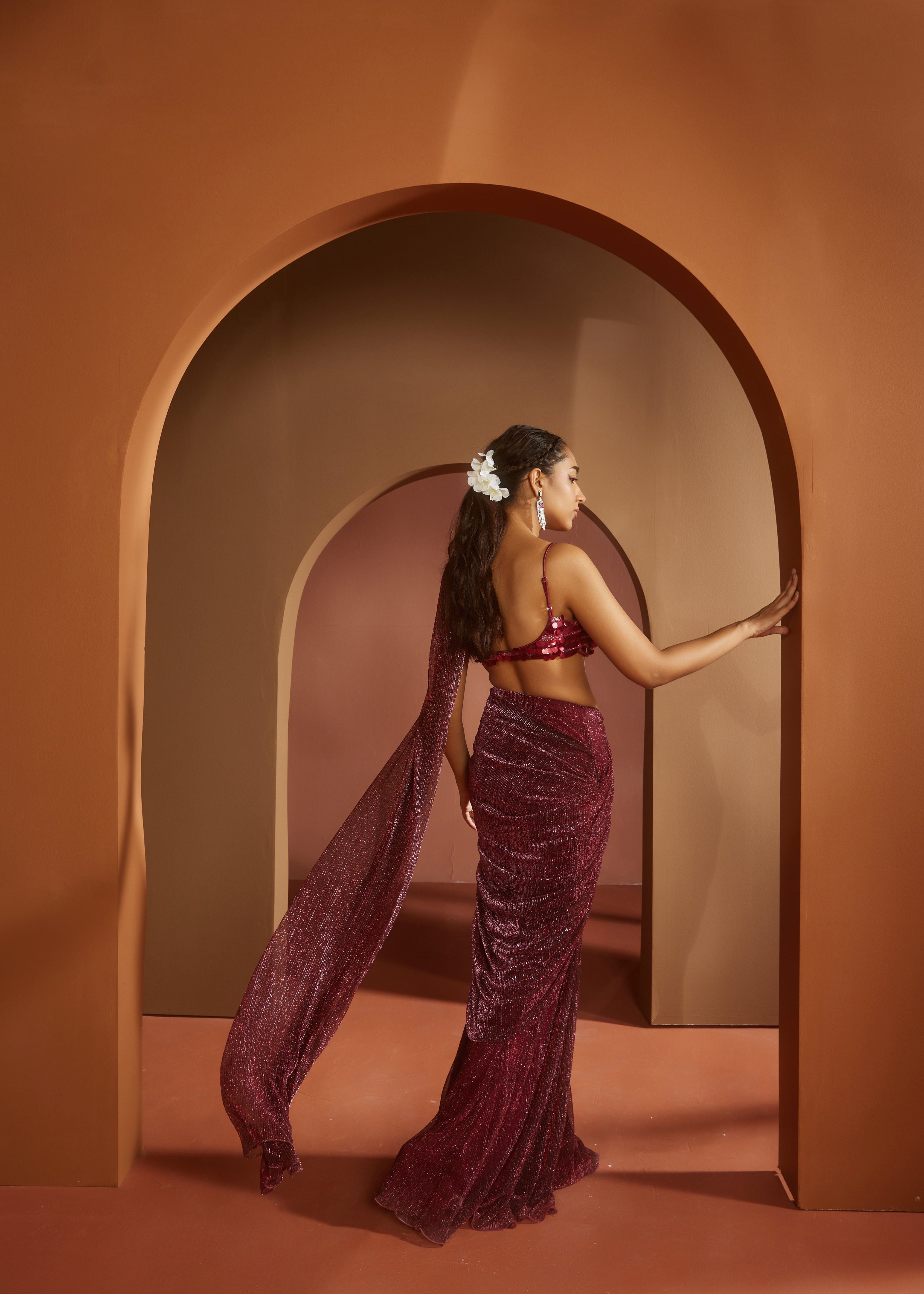 Chic woman in a Humaida Maroon Shimmer Pre-Draped Saree Set, exuding vibrant elegance
