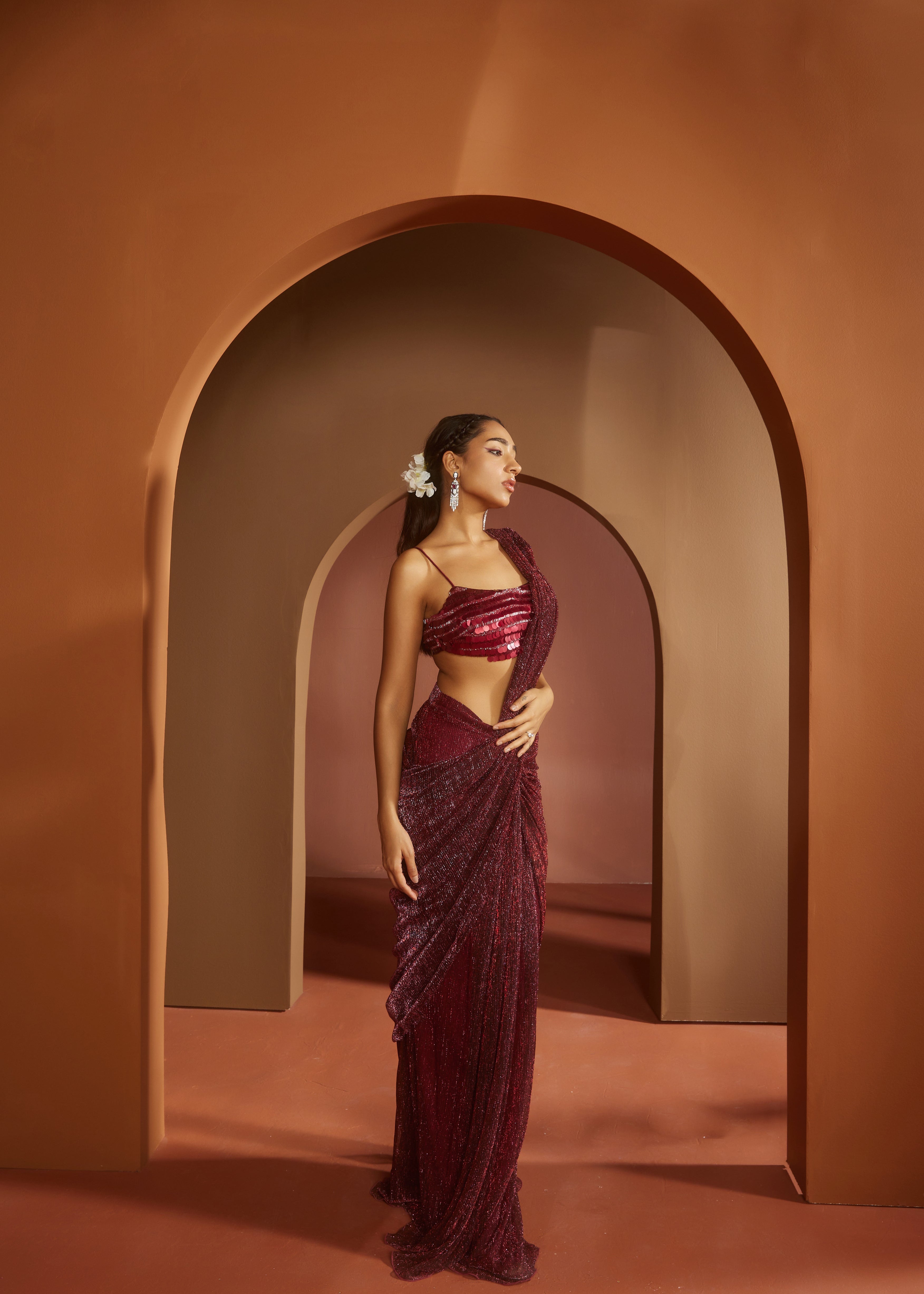 Chic woman in a Humaida Maroon Shimmer Pre-Draped Saree Set, exuding vibrant elegance