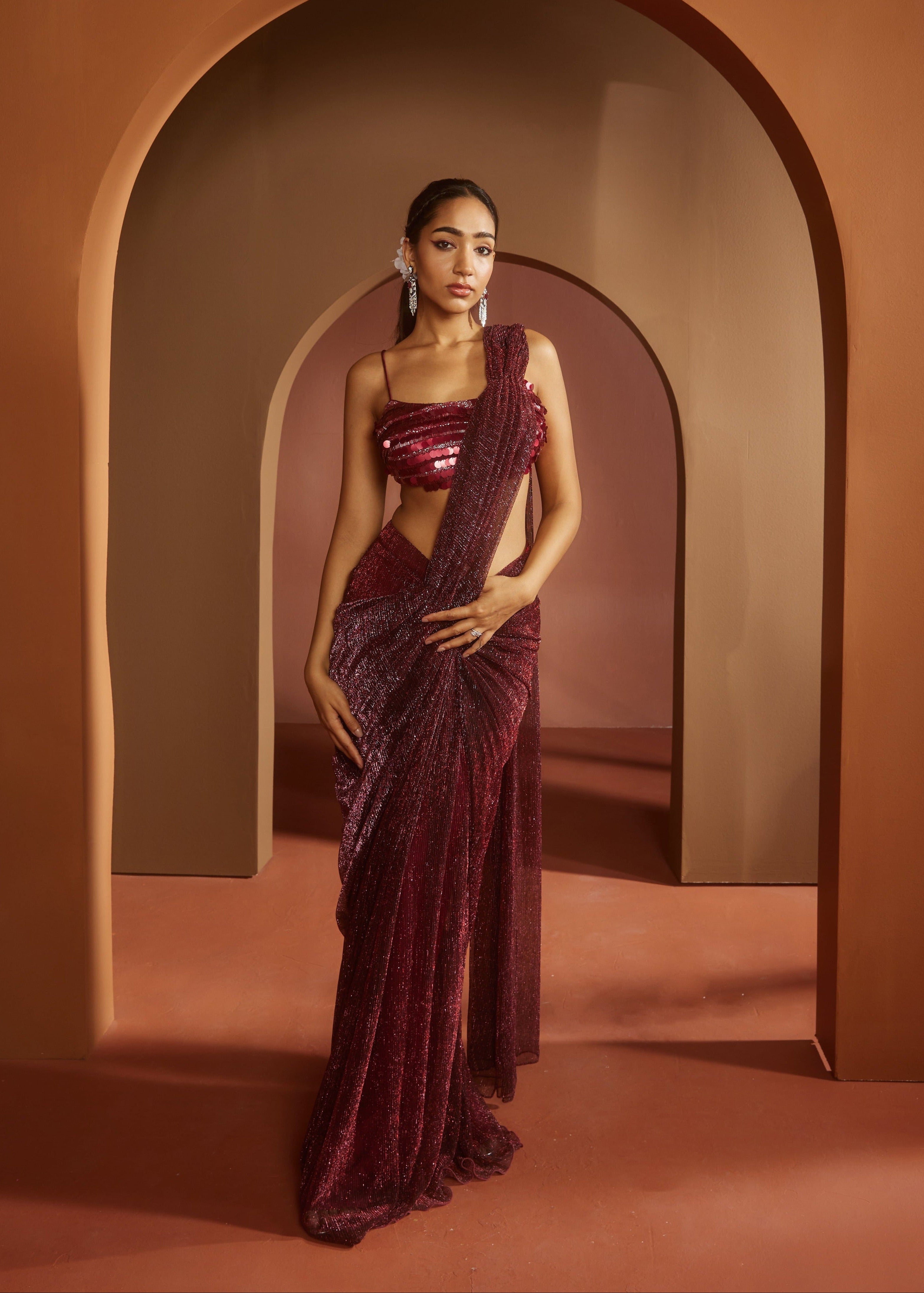 Chic woman in a Humaida Maroon Shimmer Pre-Draped Saree Set, exuding vibrant elegance