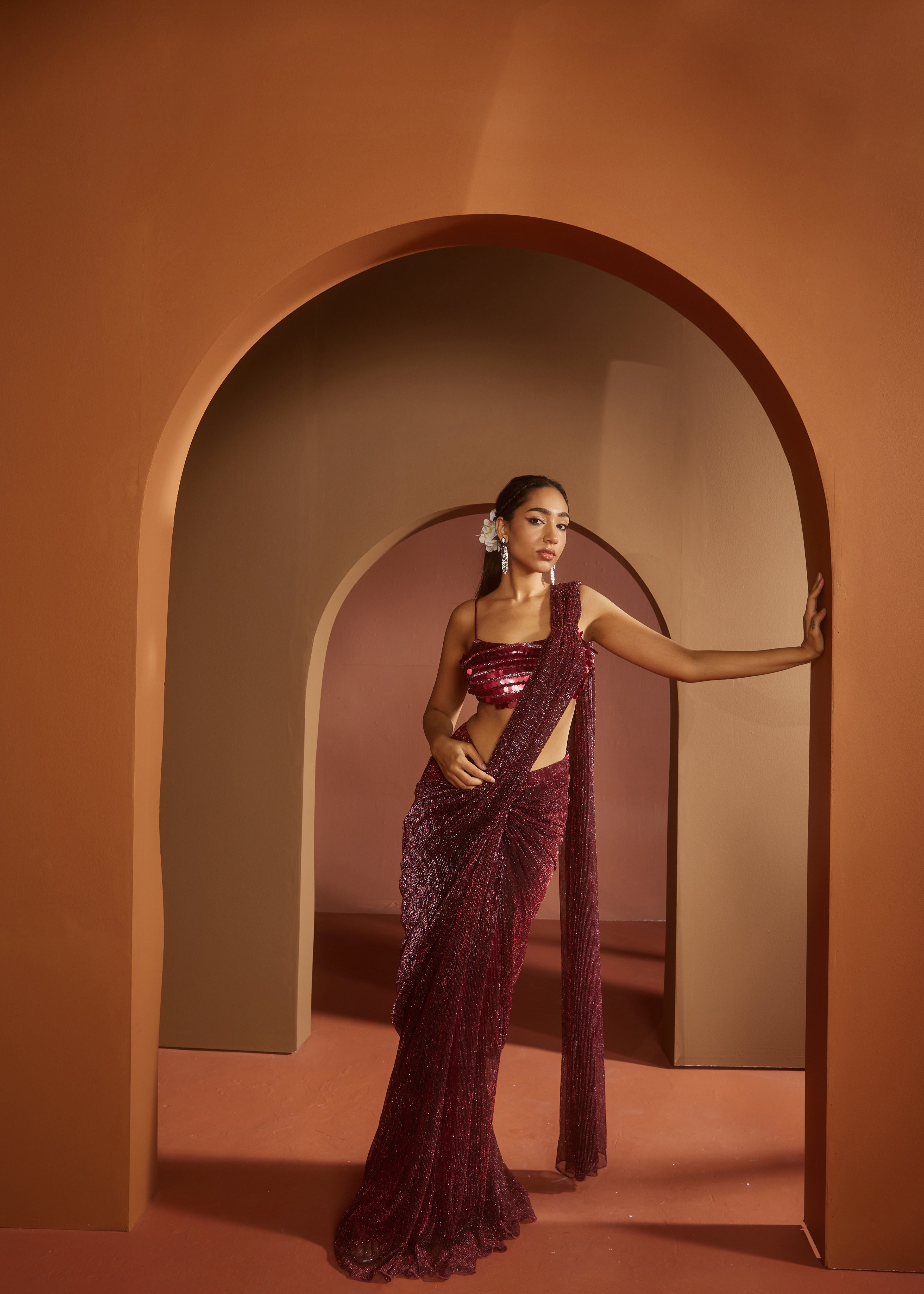 Chic woman in a Humaida Maroon Shimmer Pre-Draped Saree Set, exuding vibrant elegance